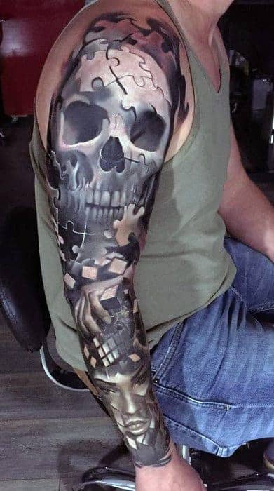 Man with detailed skull and puzzle piece tattoo sleeve on his left arm