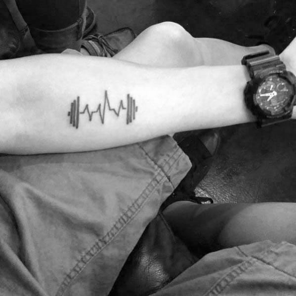 Minimalist forearm tattoo of a barbell with heartbeat line, symbolizing passion for fitness as a vital part of life.