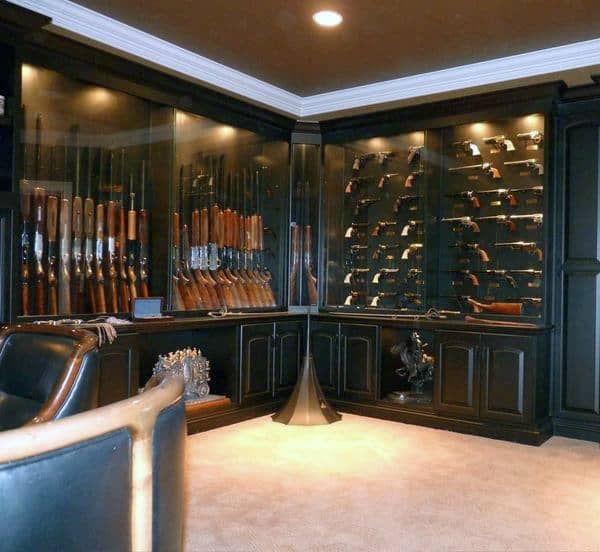 A sophisticated basement gun room with black cabinetry, glass display cases, and soft lighting for a modern yet classic ambiance.