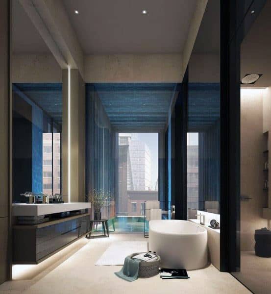 Modern bathroom with a freestanding tub, large windows, and blue accents