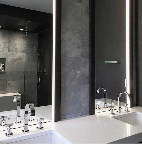 Modern bathroom with double sinks, mirrored vanity, and glass shower enclosure