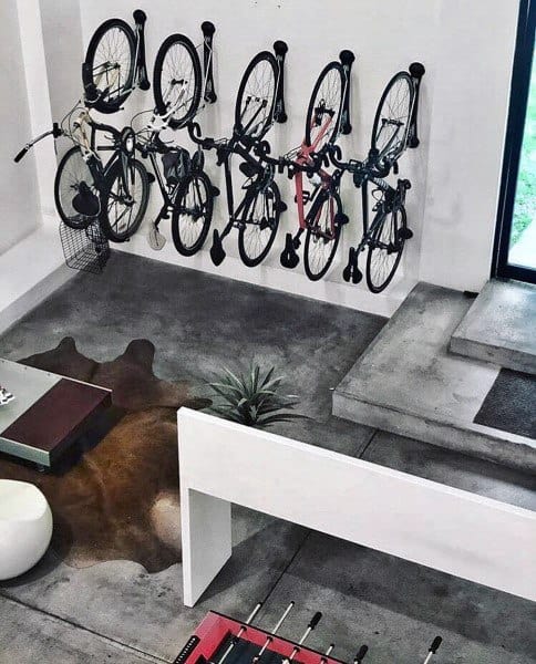 Modern indoor space with multiple bikes mounted vertically on a white wall.