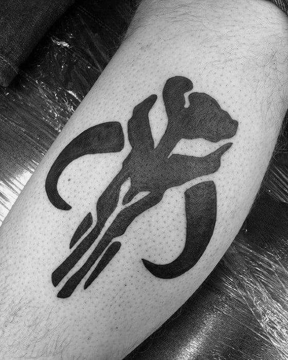 Solid black Mythosaur skull tattoo from Star Wars, inked with clean lines and curved horns on the inner forearm.