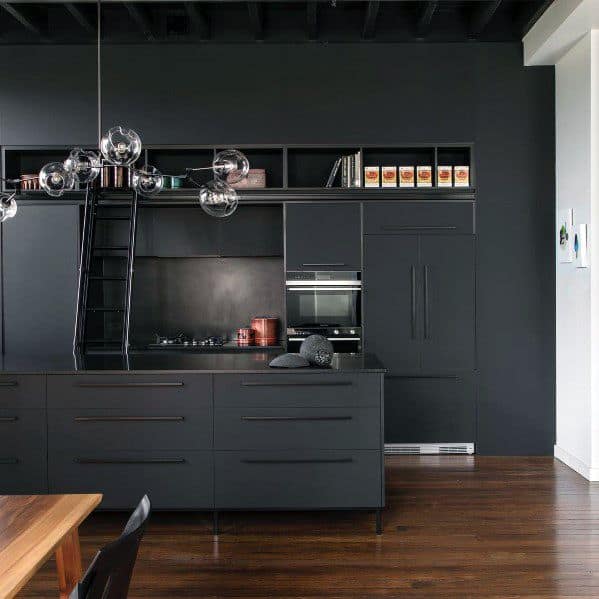 Modern black kitchen with sleek cabinets, open shelving, ladder, and glass globe chandelier.