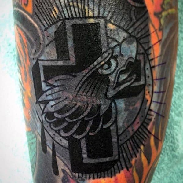 Blast over tattoo of a stylized cross with a bird's head and wings on a colorful background