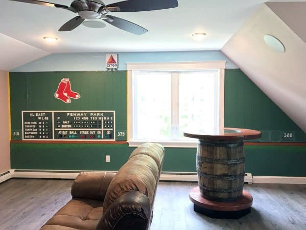 Sports-themed room with Fenway Park wall design, leather recliner, and barrel-style table.