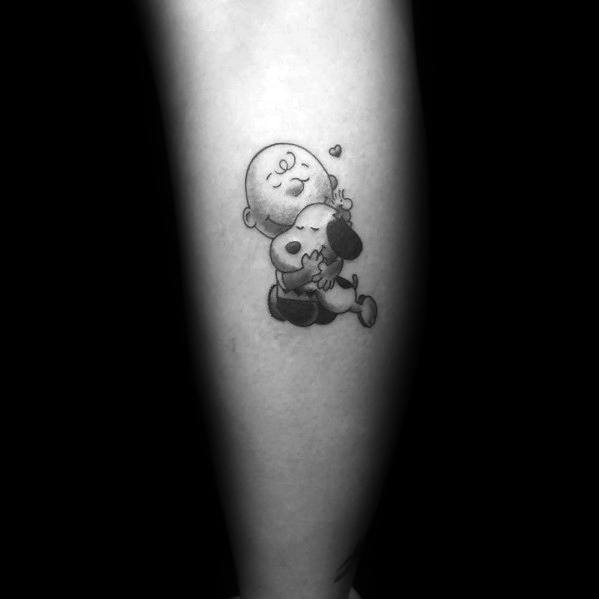 Small black and white Charlie Brown and Snoopy tattoo, featuring a loving hug with a tiny heart, symbolizing warmth and friendship.