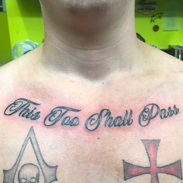 A bold chest tattoo of *"This Too Shall Pass"*, symbolizing resilience and the temporary nature of hardships.