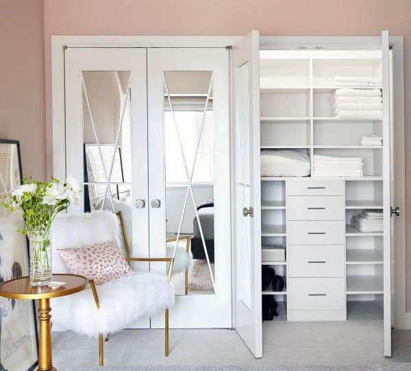A stylish closet with white French doors featuring diamond-patterned glass, offering a chic and functional design for any room