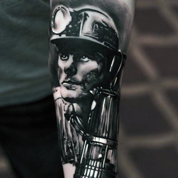Black and grey tattoo of a focused coal miner wearing a helmet with a lamp, holding a traditional mining lantern.