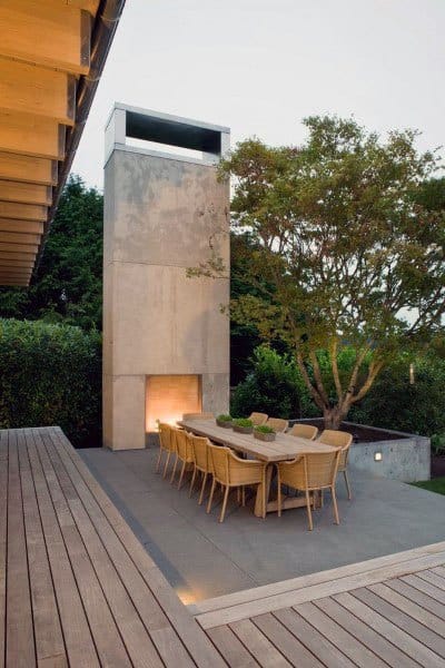 concrete slab with wood deck and dining table fireplace