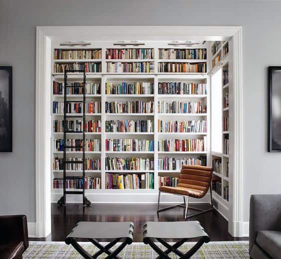 A cozy library with bookshelves, a brown leather chair, and a sliding ladder