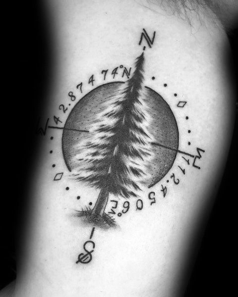 Detailed pine tree coordinate tattoo with a compass design, featuring fine shading and bold black linework, symbolizing nature and a special location.