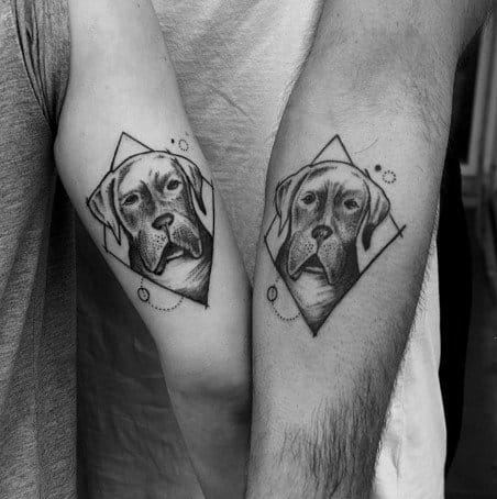 Matching forearm tattoos of a dog portrait framed in geometric shapes, symbolizing shared love and memory of a beloved pet.