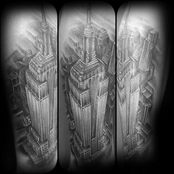 Realistic Empire State Building tattoo showcasing a detailed aerial perspective, shaded in black and grey on a man's arm.