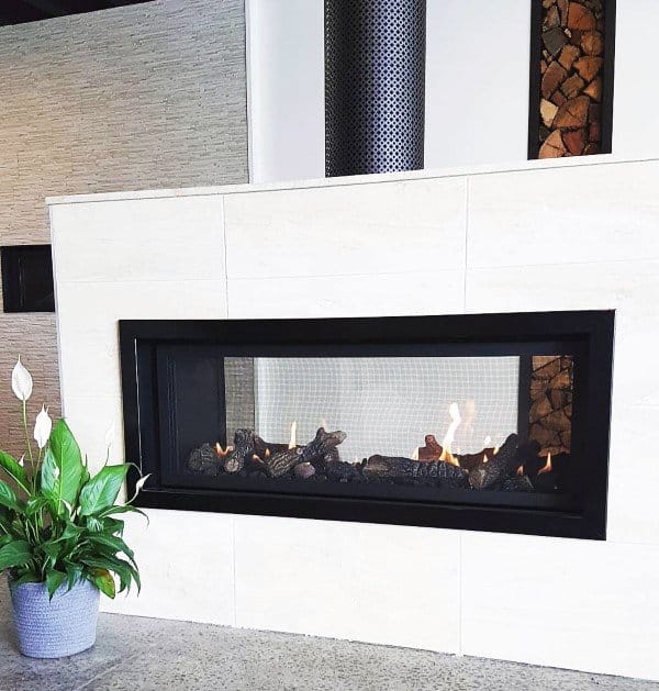 Modern gas fireplace with a black frame and white tiled surround.