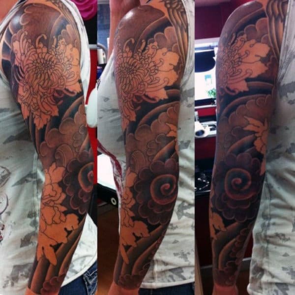 Full-sleeve tattoo featuring intricate floral and abstract patterns on someone's arm