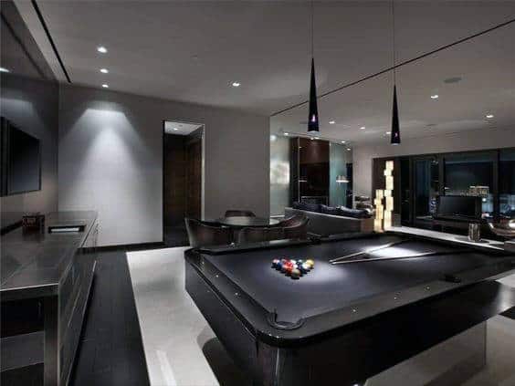Sleek modern game room with a black pool table, elegant seating, and ambient lighting