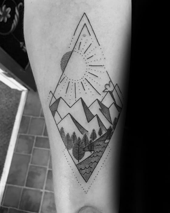 Diamond-shaped tattoo of a mountain scene with sun rays, pine trees, river, and dotted accents for a clean geometric look.