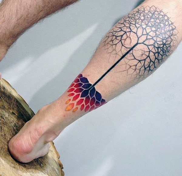 A leg tattoo featuring a tree design with multicolored roots in red, purple, and yellow