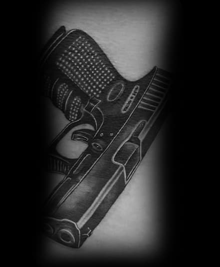 Realistic black and grey tattoo of a Glock pistol, featuring fine details on the grip and slide, creating a bold and striking design.