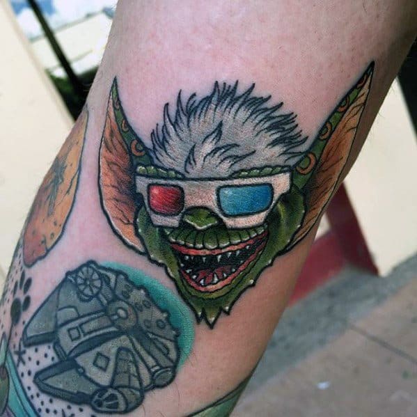 Gremlin tattoo with white hair, 3D glasses, and a mischievous grin, blending nostalgia with a fun, colorful design.