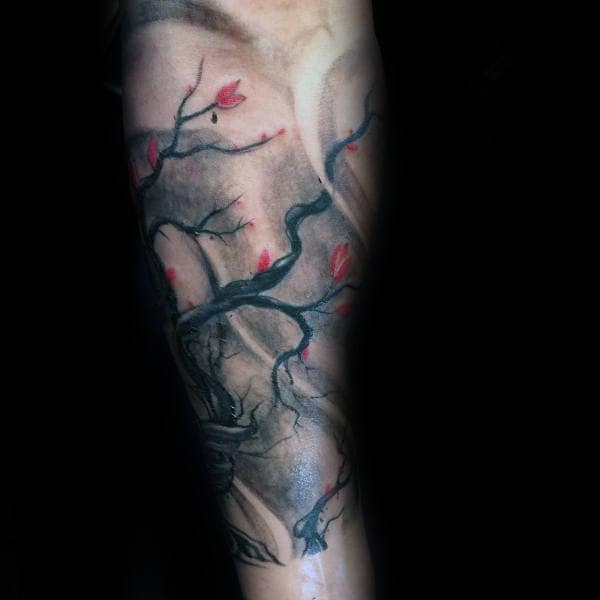 Dark, shaded arm tattoo featuring a twisted cherry blossom tree with delicate red petals, creating a moody and artistic design