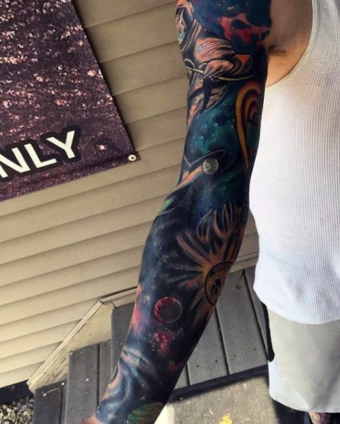 A person with a detailed space-themed sleeve tattoo on their arm