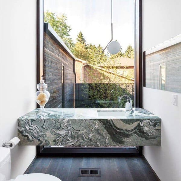 Modern half bath with a marbled sink, large window, pendant light, and outdoor view