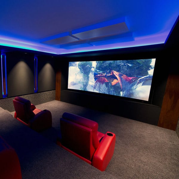 A cozy home theater with red seats, a large fantasy movie screen, and soothing blue ambient lighting