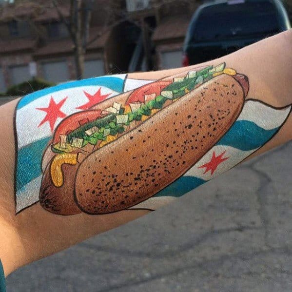 Chicago-style hot dog tattoo with mustard, onions, and relish on a bun, surrounded by the Chicago flag on the forearm.