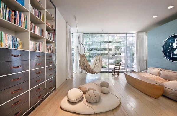 Modern indoor hammock in a bright reading room with bookshelves and cozy seating options.