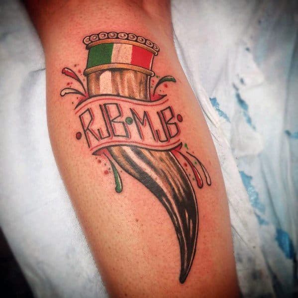Italian horn tattoo with a rustic design, tricolor flag, and initials on a banner, symbolizing heritage, strength, and protection.
