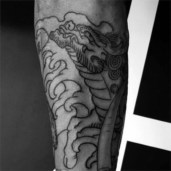 Forearm Kirin tattoo outline with swirling cloud patterns, showcasing the creature’s head and scales in a bold traditional design.