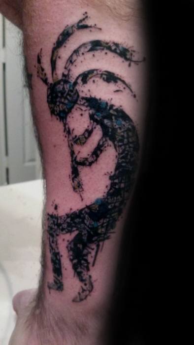 Grunge-style Kokopelli tattoo with a distressed black and blue texture, giving it a raw, abstract look on the forearm.
