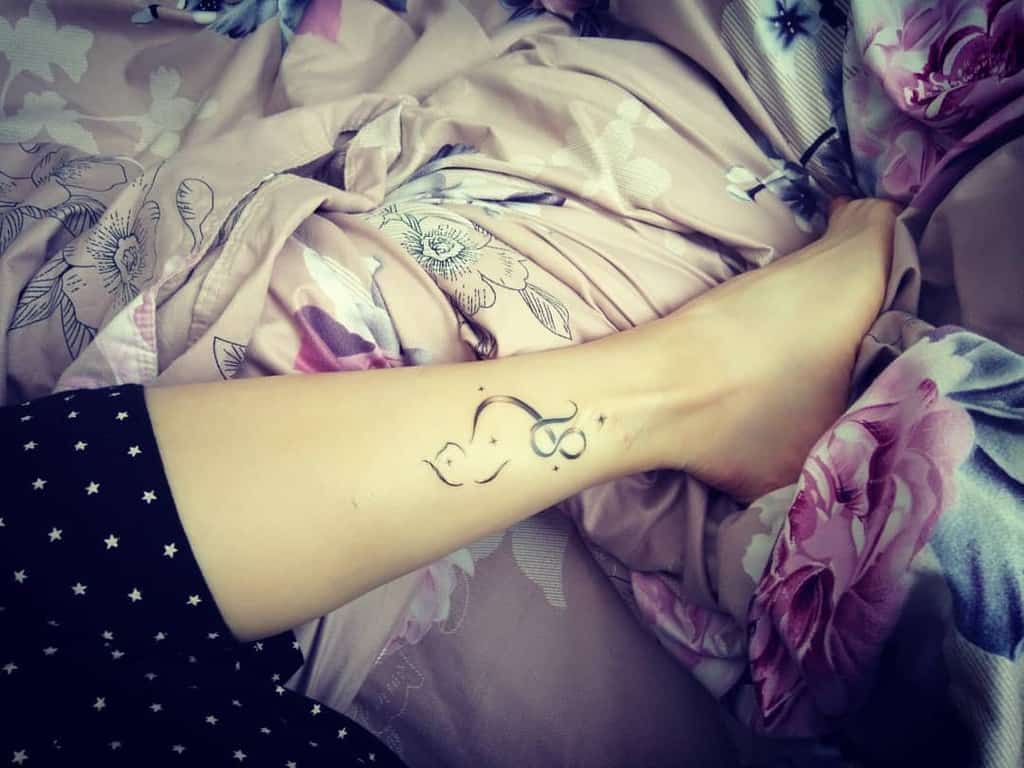 Simple and graceful Leo tattoo on the calf, incorporating soft curves and minimalist design elements.