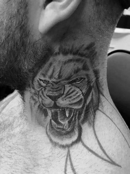 Fierce lion neck tattoo with an intense gaze and open mouth, featuring bold shading and fine details for a powerful and dynamic look.