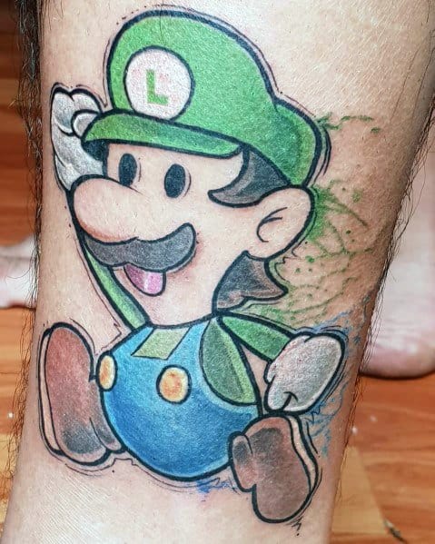 Tattoo of Luigi in a dynamic pose, wearing his green hat and blue overalls, with a watercolor-style green background on the leg.