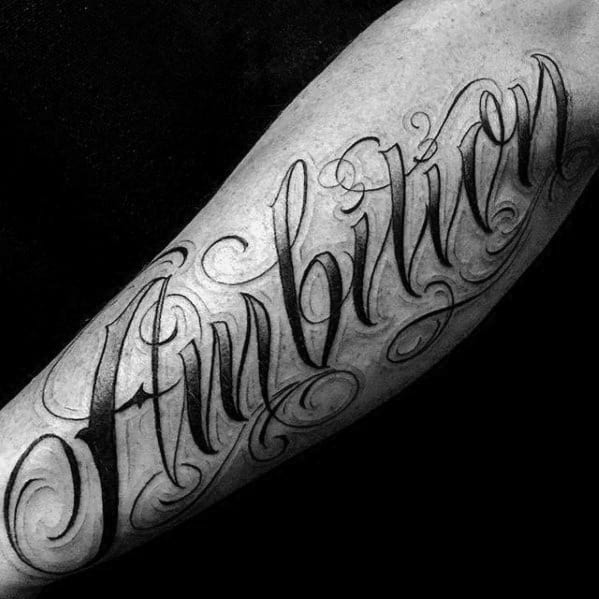 Tattoo of "Ambition" elegantly swirls across the forearm, exuding a sense of purpose