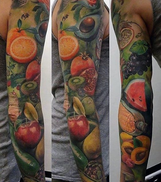 Vibrant full sleeve tattoo featuring hyper-realistic fruits like avocado, watermelon, kiwi, and citrus in a lush, colorful composition.