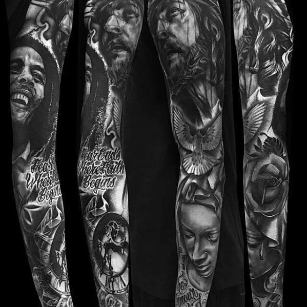 Full sleeve black and gray tattoo featuring Bob Marley, Jesus, a dove, a weeping woman, clock, rose, and the quote “Fear ends where faith begins.”