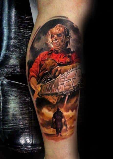 Hyper-realistic tattoo of Leatherface in a red shirt holding a chainsaw, with a dramatic sunset scene and silhouette below.
