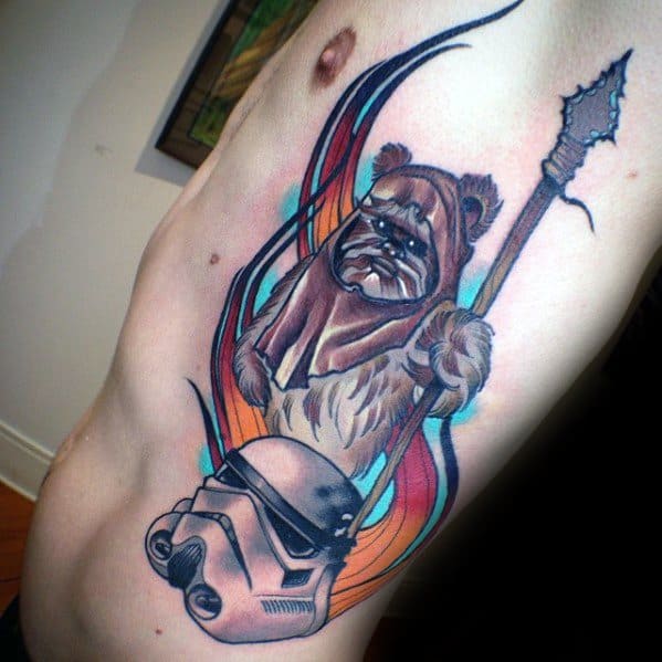 Stylized Ewok tattoo with spear and Stormtrooper helmet, accented by colorful swirling lines across the ribcage.