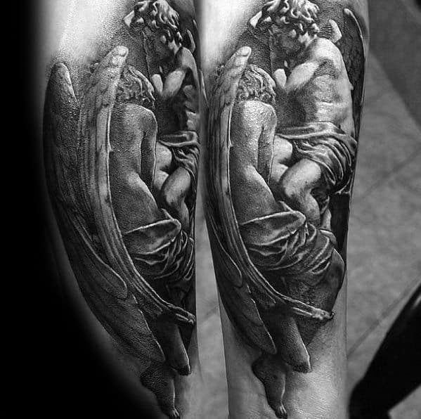 A black and grey tattoo on the forearm depicting two angels in an intimate embrace, with their wings flowing around them.
