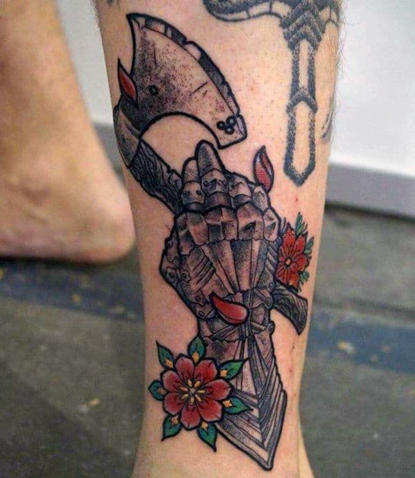 Tattoo of a medieval gauntlet gripping a battle axe, surrounded by red flowers with green leaves and blood-like red accents.