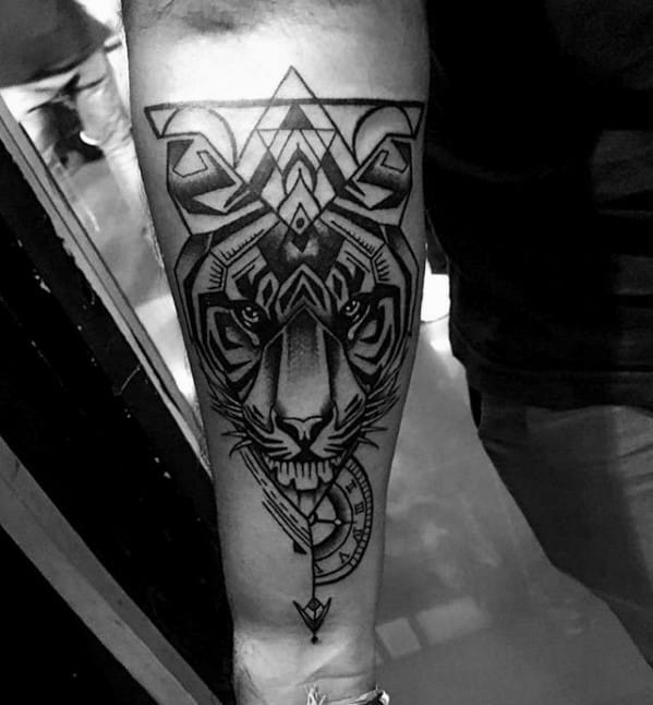 Forearm tattoo of a geometric tiger with bold black lines, angular shapes, and compass-style elements for a fierce modern look.