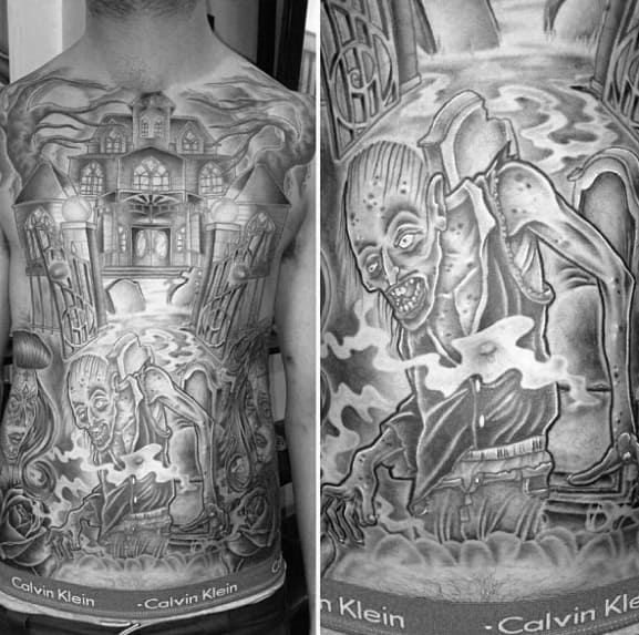 Full torso tattoo of a haunted mansion with eerie gates, ghostly hands above, and a creepy zombie emerging from swirling mist below.