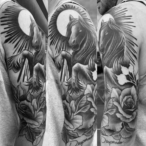 Black and grey tattoo of a rearing horse under a radiant sun, surrounded by roses and floral elements on the upper arm