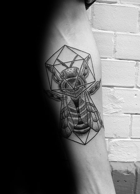 Detailed bee tattoo merged with an icosahedron on the inner arm, combining realism and geometric elements in black ink.