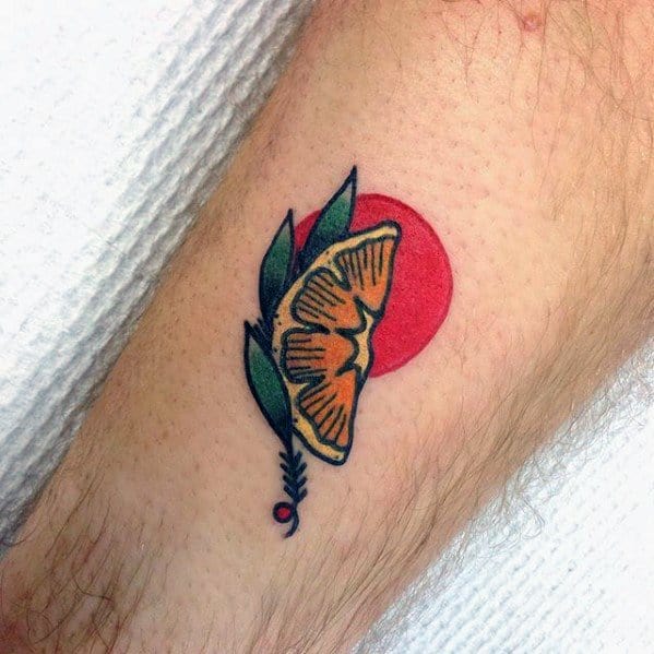 Minimalist tattoo of a lemon slice with green leaves and a bold red circle in the background, featuring clean black outlines.